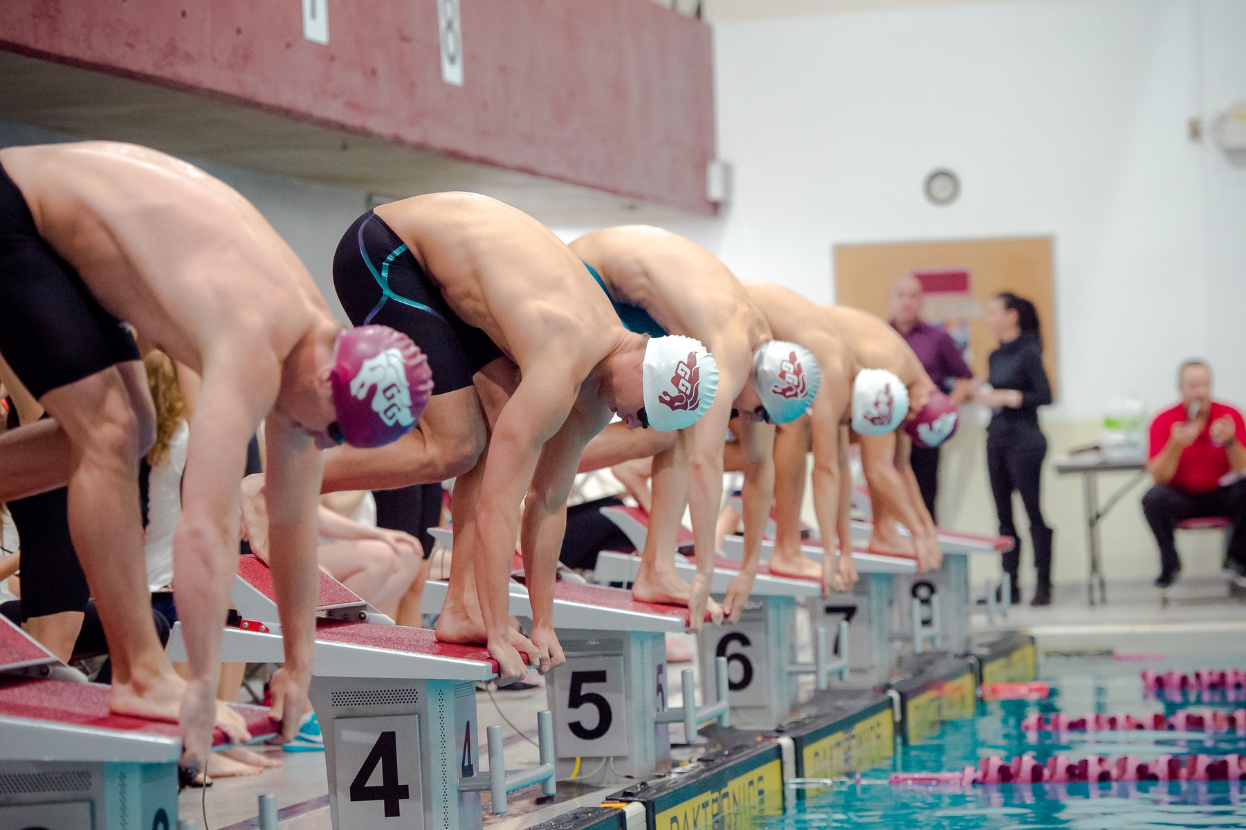Swimmers line up on blocks.