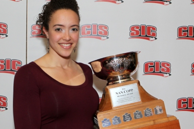 Hannah Sunley-Paisley holds the Nan Copp trophy in front of a CIS backdrop.