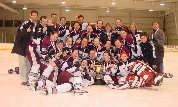 Team poses with trophy on ice.