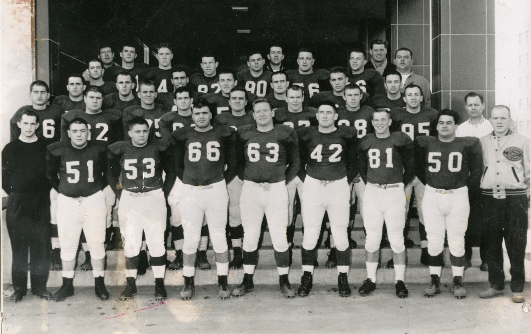 Football players stand in five rows for a team photo.