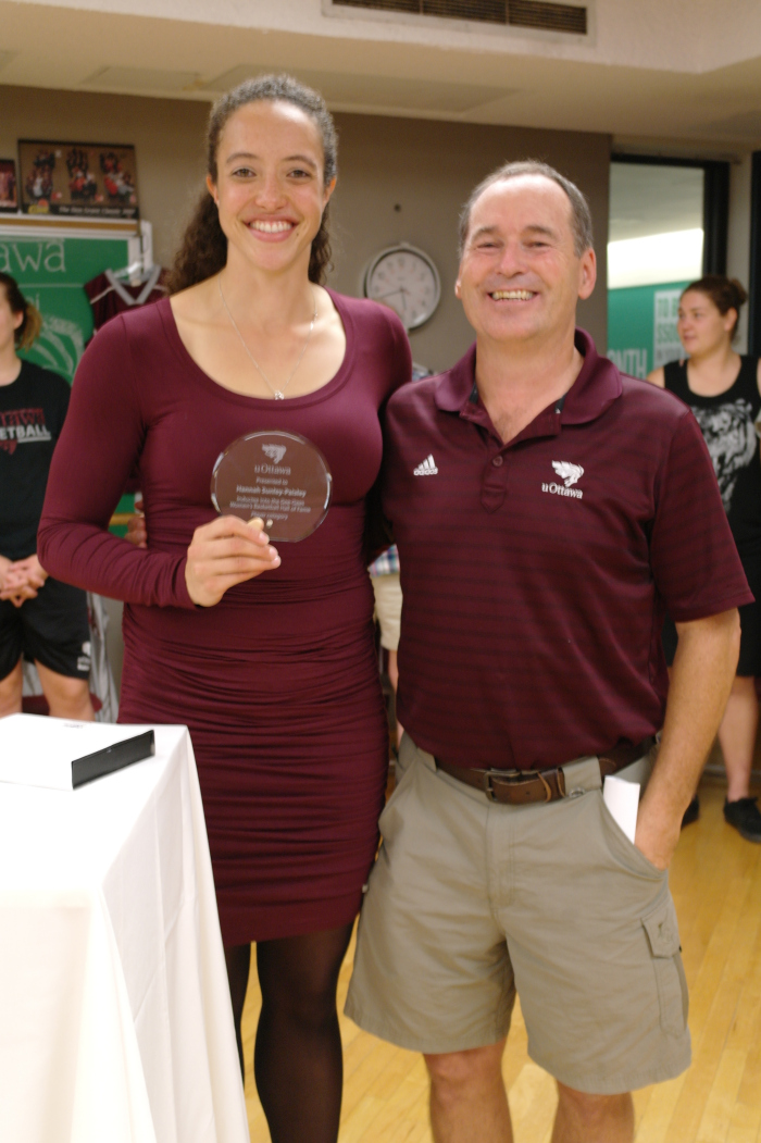 Hannah Sunley-Paisley stands with Andy Sparks, holding her Hall of Fame glass trophy.