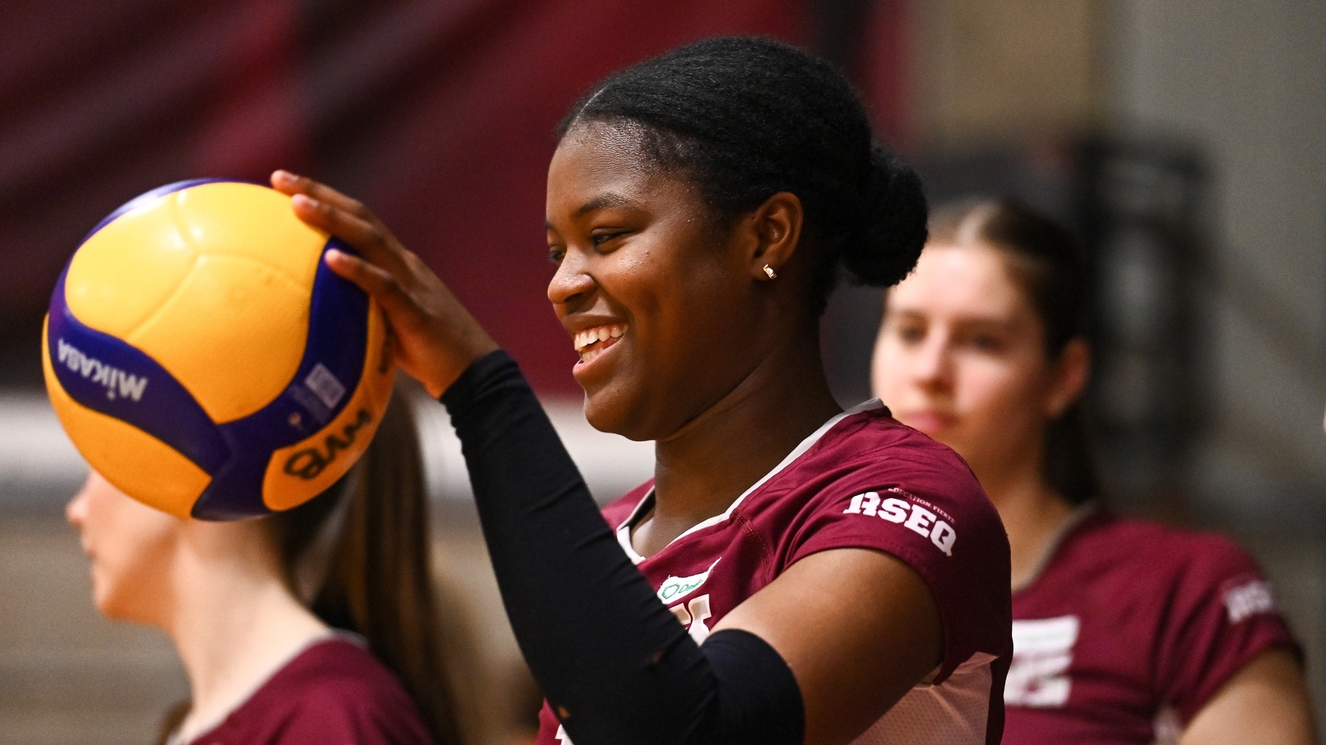 Audrey Odigie smiles while bouncing a volleyball Thumbnail